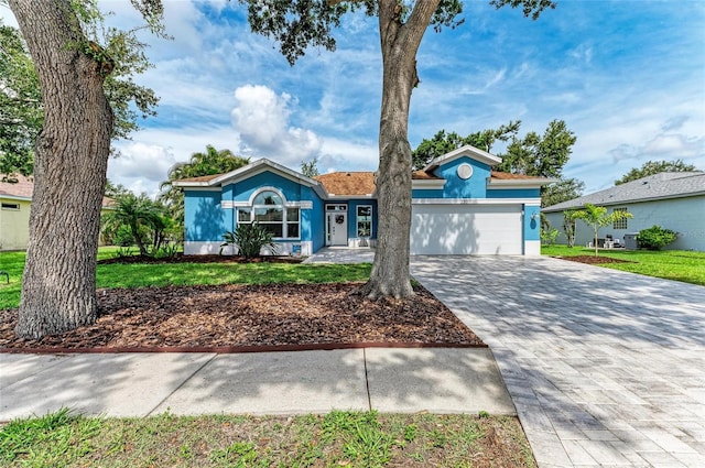 220 39th St NE, Bradenton, FL 34208 - ranch-style house with an attached garage, decorative driveway, stucco siding, and a front yard