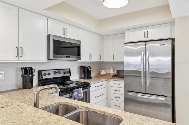 1240 Siesta Bayside Dr Unit 1240C, Sarasota, FL 34242 - kitchen with stainless steel appliances, white cabinetry, and light stone countertops