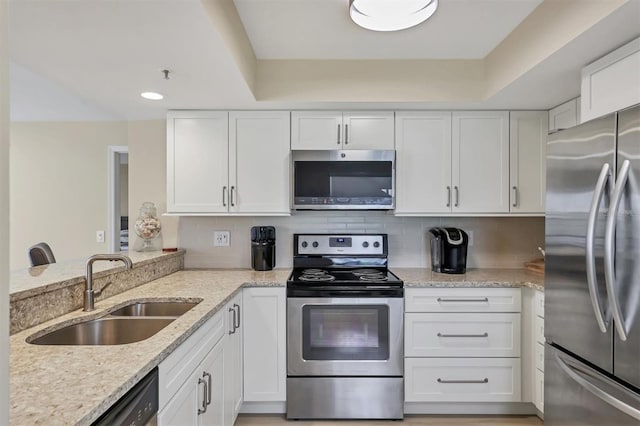 1240 Siesta Bayside Dr Unit 1240C, Sarasota, FL 34242 - kitchen with appliances with stainless steel finishes, white cabinetry, light stone countertops, backsplash, and recessed lighting
