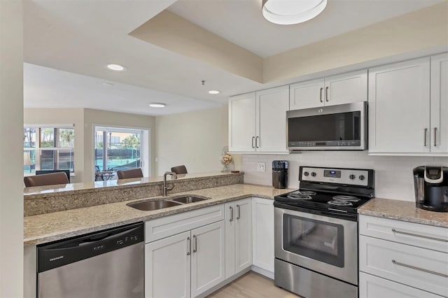 1240 Siesta Bayside Dr Unit 1240C, Sarasota, FL 34242 - kitchen featuring stainless steel appliances, white cabinetry, light stone counters, backsplash, and recessed lighting