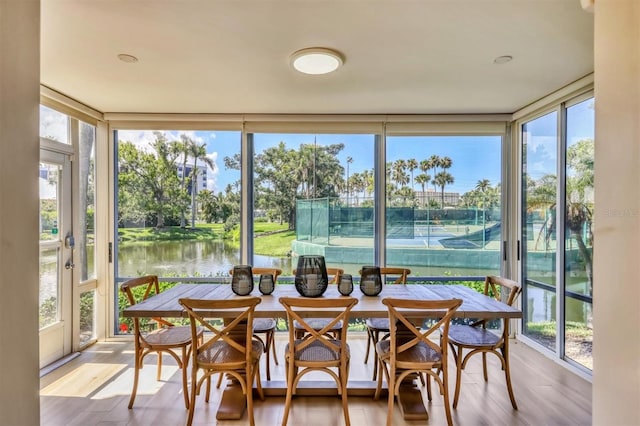 1240 Siesta Bayside Dr Unit 1240C, Sarasota, FL 34242 - sunroom / solarium with a water view, floor to ceiling windows, wood finished floors, and view of wooded area