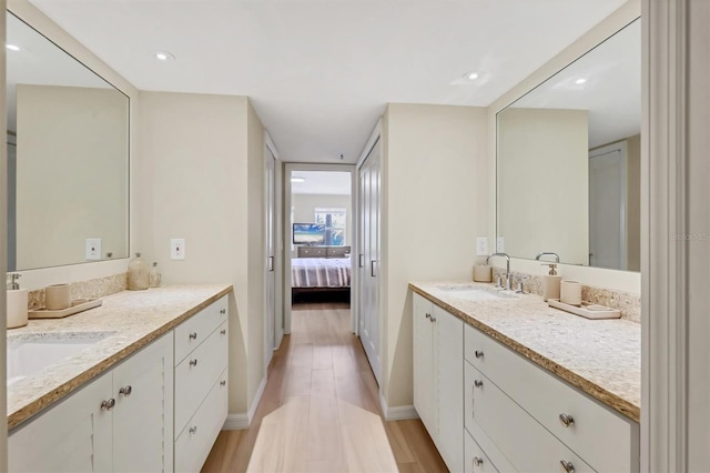 1240 Siesta Bayside Dr Unit 1240C, Sarasota, FL 34242 - bathroom featuring two vanities, ensuite bathroom, wood finished floors, and recessed lighting