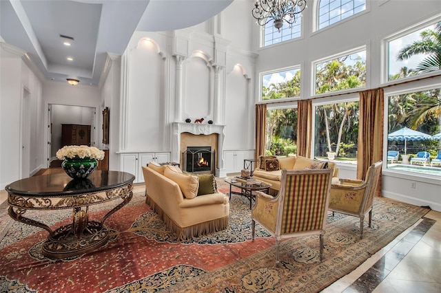 550 Dove Pointe, Osprey, FL 34229 - living room with a towering ceiling, a large fireplace, a decorative wall, and ornamental molding