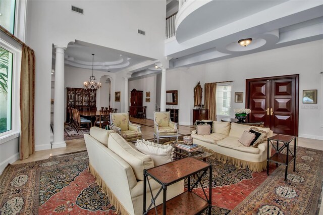 550 Dove Pointe, Osprey, FL 34229 - living area with decorative columns, a chandelier, a high ceiling, and a raised ceiling