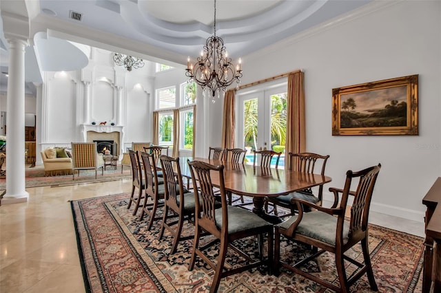 550 Dove Pointe, Osprey, FL 34229 - dining area featuring french doors, a lit fireplace, a chandelier, decorative columns, and a towering ceiling