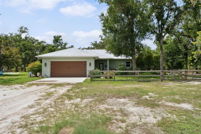 15780 Wilson Rd, Sarasota, FL 34240 - ranch-style home with an attached garage, driveway, stucco siding, a metal roof, and a standing seam roof