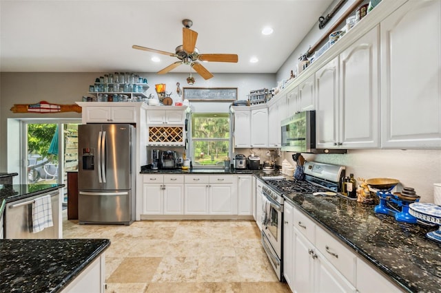 15780 Wilson Rd, Sarasota, FL 34240 - kitchen with stainless steel appliances, white cabinets, dark stone counters, ceiling fan, and recessed lighting