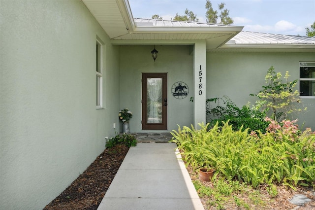15780 Wilson Rd, Sarasota, FL 34240 - doorway to property featuring stucco siding and a metal roof