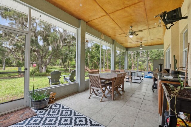 15780 Wilson Rd, Sarasota, FL 34240 - sunroom / solarium with outdoor dining area, ceiling fan, and view of scattered trees