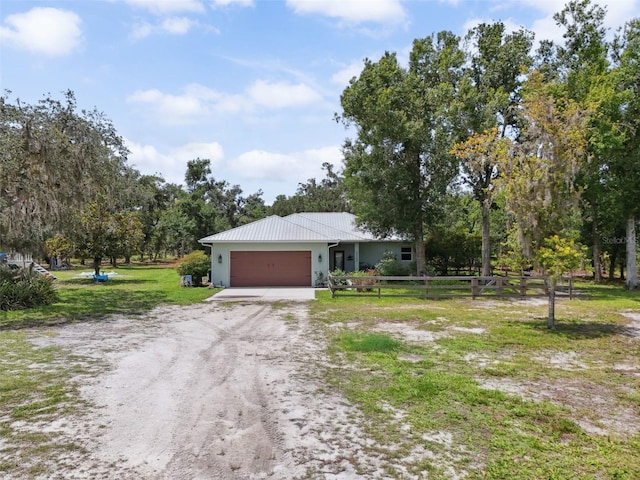 15780 Wilson Rd, Sarasota, FL 34240 - single story home featuring dirt driveway, an attached garage, a metal roof, stucco siding, and view of scattered trees