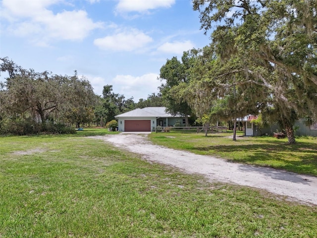 15780 Wilson Rd, Sarasota, FL 34240 - view of front facade with driveway, a garage, and a front lawn