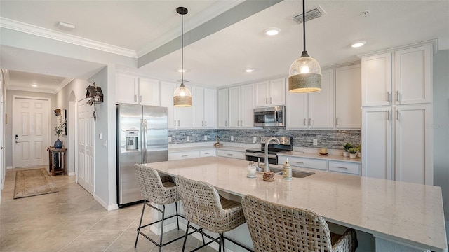1030 Tidewater Shores Loop Unit 307, Bradenton, FL 34208 - kitchen featuring appliances with stainless steel finishes, tasteful backsplash, white cabinets, a breakfast bar, and ornamental molding