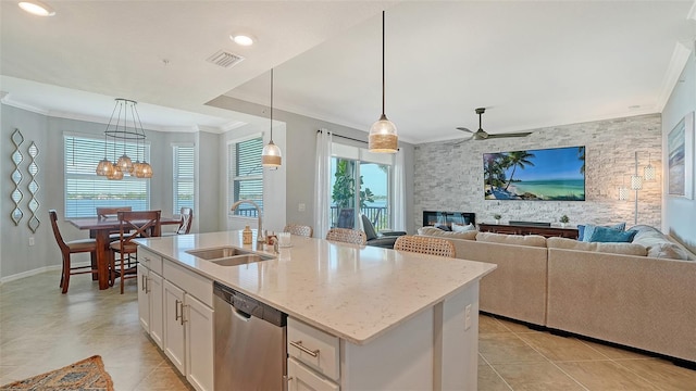 1030 Tidewater Shores Loop Unit 307, Bradenton, FL 34208 - kitchen with stainless steel dishwasher, crown molding, light tile patterned floors, light stone counters, and white cabinets