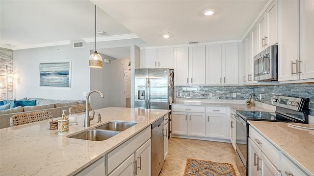 1030 Tidewater Shores Loop Unit 307, Bradenton, FL 34208 - kitchen featuring appliances with stainless steel finishes, white cabinets, ornamental molding, light tile patterned floors, and tasteful backsplash
