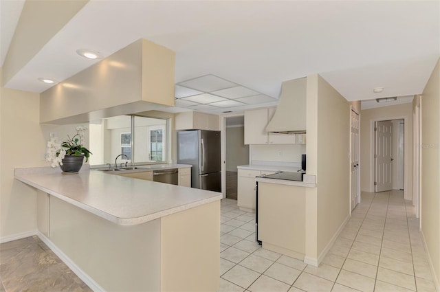 5124 Palm Aire Dr, Sarasota, FL 34243 - kitchen featuring appliances with stainless steel finishes, premium range hood, a peninsula, light countertops, and light tile patterned floors