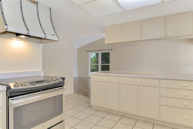 5124 Palm Aire Dr, Sarasota, FL 34243 - kitchen featuring stainless steel range with electric stovetop, ventilation hood, light countertops, cream cabinets, and light tile patterned floors