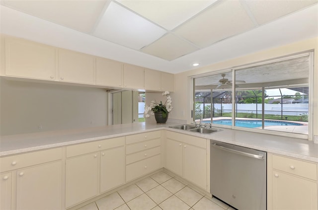 5124 Palm Aire Dr, Sarasota, FL 34243 - kitchen featuring stainless steel dishwasher, light countertops, cream cabinets, light tile patterned flooring, and ceiling fan