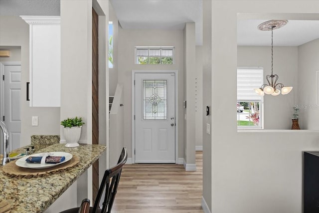 11839 Shrewsbury Ln, Parrish, FL 34219 - foyer entrance with light wood finished floors, a chandelier, and plenty of natural light