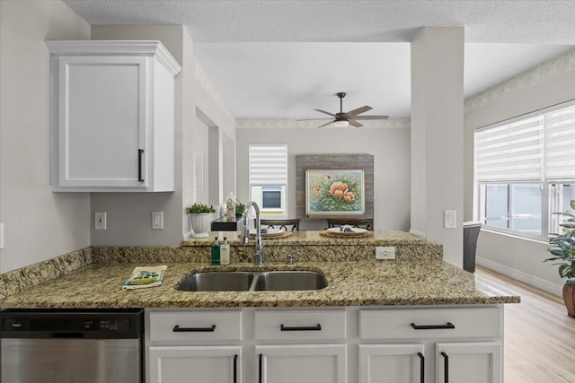 11839 Shrewsbury Ln, Parrish, FL 34219 - kitchen featuring stainless steel dishwasher, light wood finished floors, light stone counters, and a peninsula