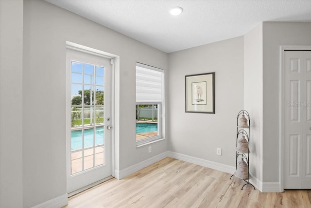 11839 Shrewsbury Ln, Parrish, FL 34219 - doorway to outside featuring light wood-style flooring and a textured ceiling