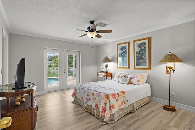11839 Shrewsbury Ln, Parrish, FL 34219 - bedroom with french doors, access to outside, light wood-style flooring, ornamental molding, and a textured ceiling