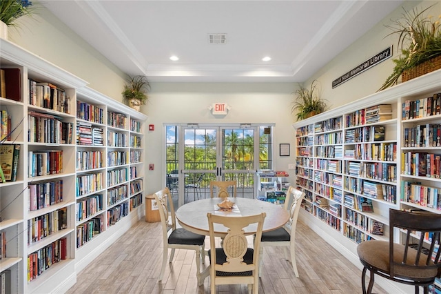 805 Waterside Ln, Bradenton, FL 34209 - living area with wall of books, wood finished floors, a raised ceiling, recessed lighting, and ornamental molding