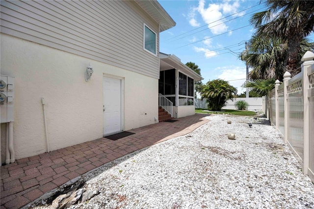 1801 Highland Rd, Osprey, FL 34229 - view of property exterior featuring stucco siding, a sunroom, a fenced backyard, and a patio area