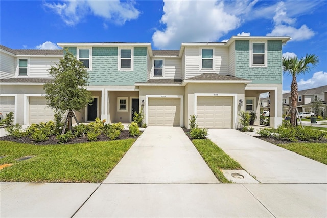 8705 Winter Breeze Way, Sarasota, FL 34241 - townhome / multi-family property featuring an attached garage, driveway, stucco siding, and a front yard