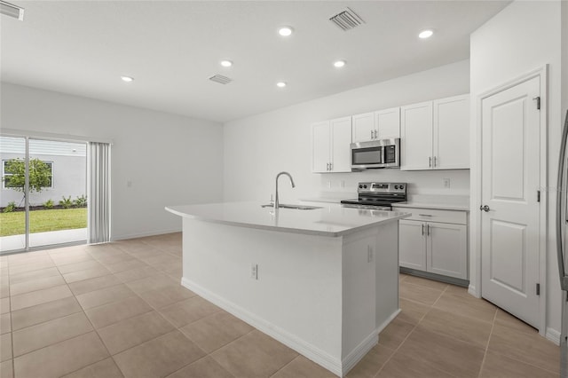 8705 Winter Breeze Way, Sarasota, FL 34241 - kitchen featuring appliances with stainless steel finishes, a center island with sink, light tile patterned floors, light countertops, and recessed lighting