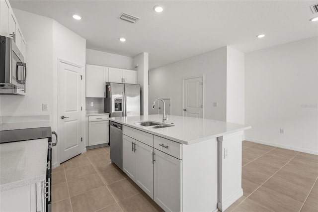 8705 Winter Breeze Way, Sarasota, FL 34241 - kitchen with stainless steel appliances, an island with sink, white cabinets, light countertops, and light tile patterned flooring