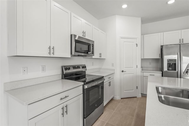 8705 Winter Breeze Way, Sarasota, FL 34241 - kitchen with stainless steel appliances, white cabinetry, light countertops, recessed lighting, and light tile patterned flooring