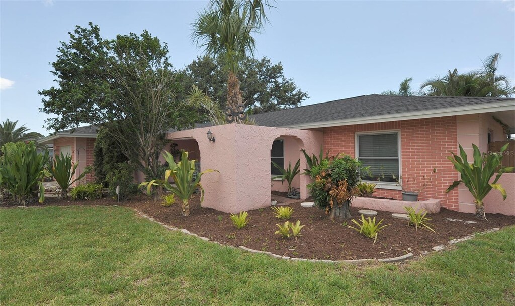 1308 63rd St NW, Bradenton, FL 34209 - ranch-style house with brick siding, a front lawn, and roof with shingles