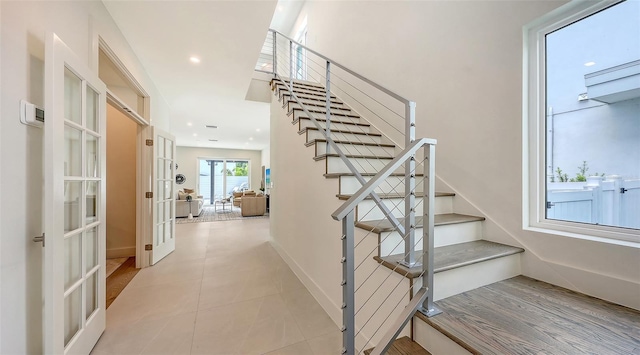 2590 Floyd St, Sarasota, FL 34239 - staircase with french doors, tile patterned floors, and recessed lighting