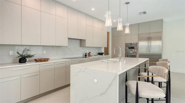 2590 Floyd St, Sarasota, FL 34239 - kitchen featuring a breakfast bar area, stainless steel appliances, backsplash, an island with sink, and recessed lighting