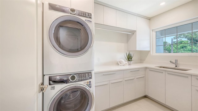 2590 Floyd St, Sarasota, FL 34239 - laundry room with stacked washing machine and dryer, cabinet space, and light tile patterned flooring