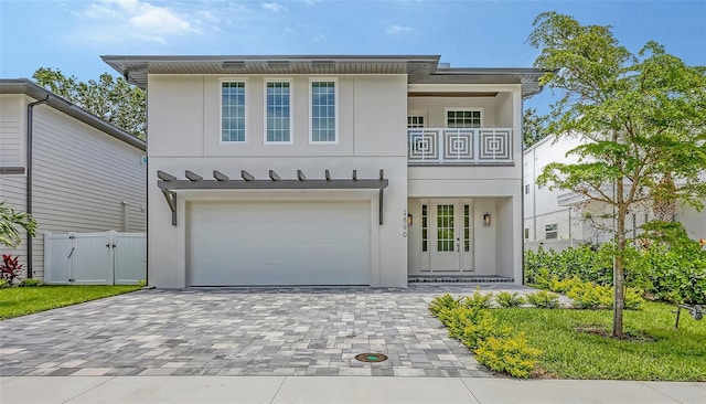 2590 Floyd St, Sarasota, FL 34239 - view of front of home featuring stucco siding, a garage, a balcony, decorative driveway, and a gate