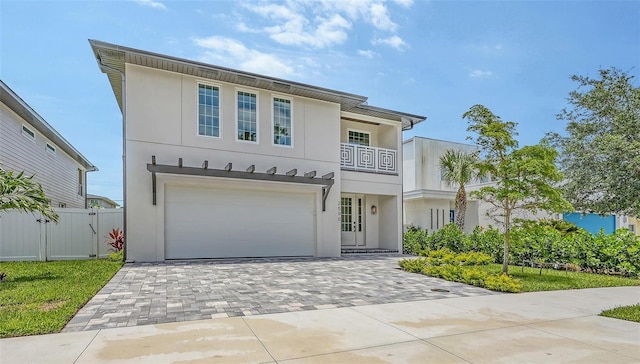 2590 Floyd St, Sarasota, FL 34239 - view of front of home with stucco siding, decorative driveway, an attached garage, and a balcony