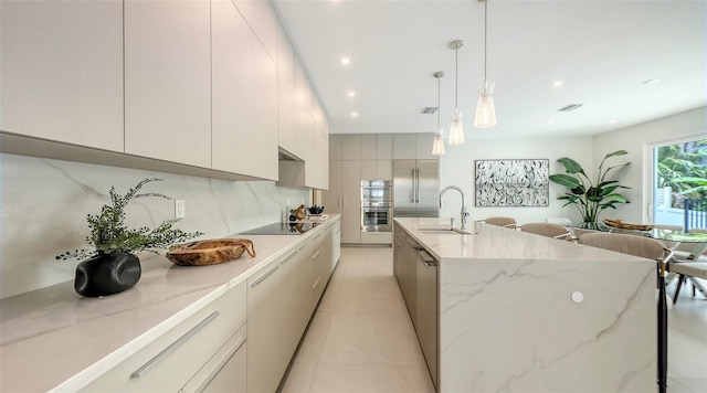 2590 Floyd St, Sarasota, FL 34239 - kitchen featuring modern cabinets, backsplash, a kitchen island with sink, double oven, and recessed lighting