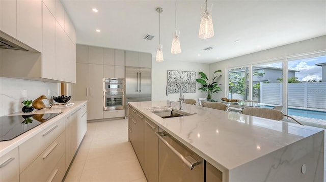 2590 Floyd St, Sarasota, FL 34239 - kitchen with appliances with stainless steel finishes, modern cabinets, an island with sink, hanging light fixtures, and recessed lighting