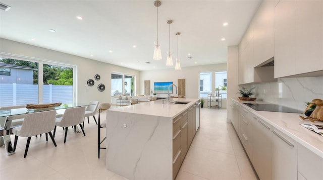 2590 Floyd St, Sarasota, FL 34239 - kitchen featuring modern cabinets, healthy amount of natural light, black electric stovetop, recessed lighting, and tasteful backsplash
