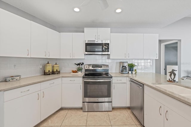 5206 19th Ave W, Bradenton, FL 34209 - kitchen featuring appliances with stainless steel finishes, light countertops, white cabinets, backsplash, and light tile patterned floors