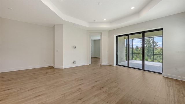 248 Altamura Cir, Nokomis, FL 34275 - spare room featuring a raised ceiling, light wood-style floors, and recessed lighting