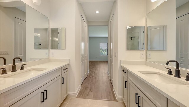 248 Altamura Cir, Nokomis, FL 34275 - full bathroom featuring two vanities, recessed lighting, and wood finished floors