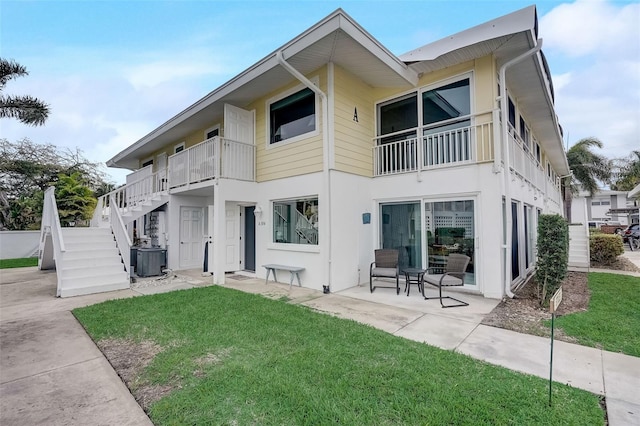 999 Inlet Cir Unit 103, Venice, FL 34285 - back of house with a yard, stairs, a patio area, and stucco siding