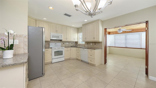 2088 Grove St, Sarasota, FL 34239 - kitchen with white appliances, a chandelier, light tile patterned floors, decorative backsplash, and recessed lighting