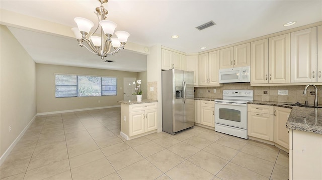 2088 Grove St, Sarasota, FL 34239 - kitchen featuring white appliances, decorative backsplash, a chandelier, light tile patterned flooring, and recessed lighting