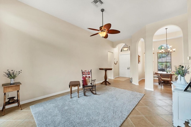 6312 41st Ct E, Sarasota, FL 34243 - living area with arched walkways, a chandelier, light tile patterned flooring, a ceiling fan, and a towering ceiling