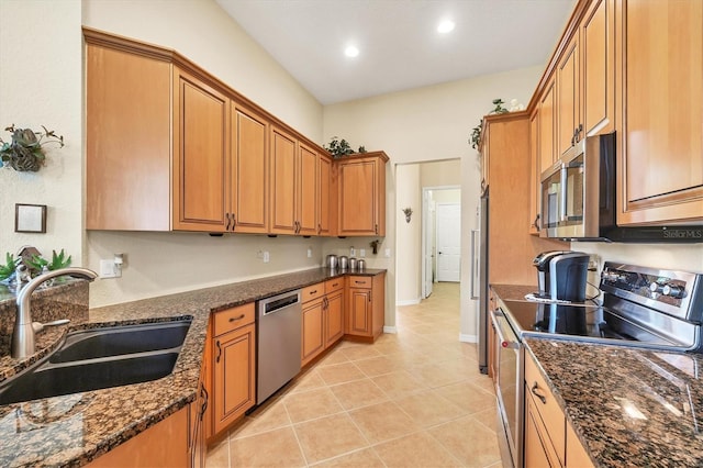 6312 41st Ct E, Sarasota, FL 34243 - kitchen with appliances with stainless steel finishes, light tile patterned floors, dark stone counters, brown cabinets, and recessed lighting