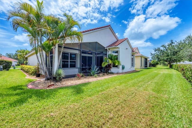 6312 41st Ct E, Sarasota, FL 34243 - rear view of house featuring stucco siding, a yard, glass enclosure, and a tile roof