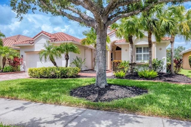 6312 41st Ct E, Sarasota, FL 34243 - mediterranean / spanish-style house featuring stucco siding, a tile roof, a garage, and a front lawn